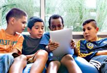 F我们的 boys sitting on a beanbag staring at tablet screen